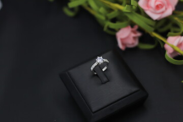 Fine jewelry with diamond with black background and sweet pink rose. Jewelry shop concept