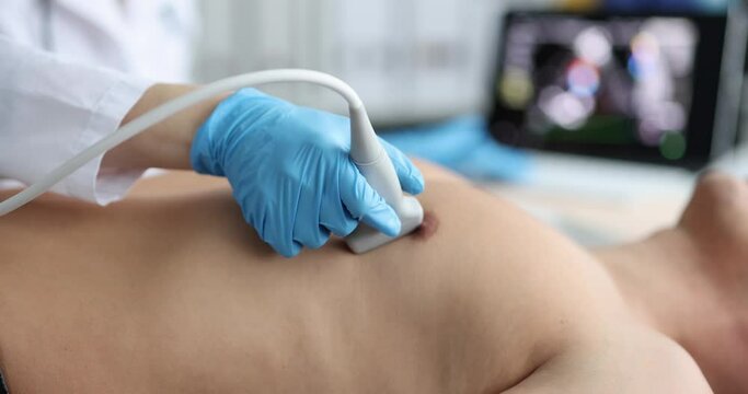 Doctor uses ultrasound machine to scan heart of male patient