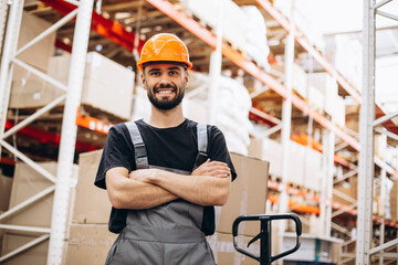 Workman at the factory with pulling jack checking goods