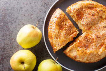 Apple pie with cheese crust closeup in the plate on the table. Horizontal top view from above