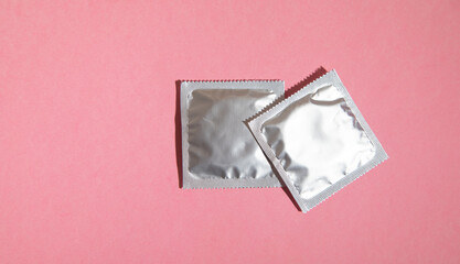 Condom on the pink background.