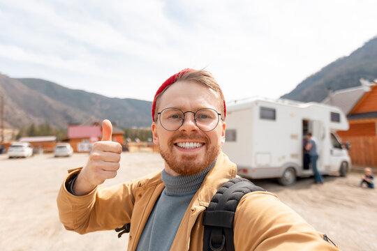 Concept vanlife lifestyle adventure, vacation van. Young man hipster traveler making selfie background camper car
