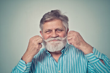 Funny hipster senior man with mustache and beard modeling during a photoshooting.