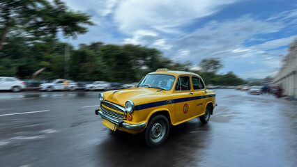 Motion blurred famous yellow taxi or cab of Kolkata, West Bengal, India