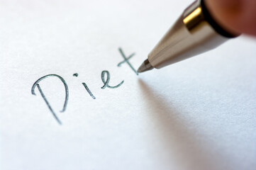 Close up image of writing a word DIET on a notebook paper.