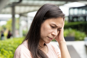 Serious and worried middle age woman having headache problem
