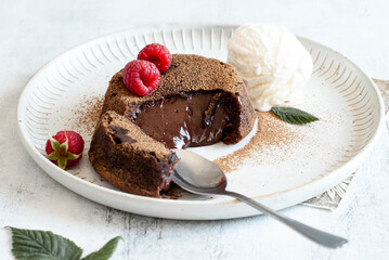Chocolate fondant with ice cream in a plate, on a light background