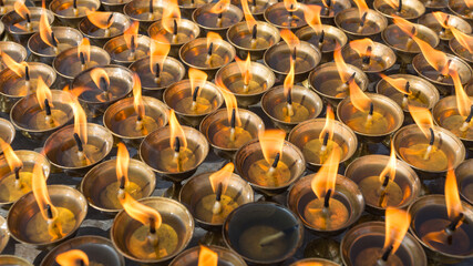 Obraz premium Burning prayer candles in buddhist temple, close up image