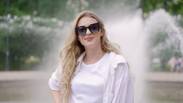 Smiling woman in sunglasses in park