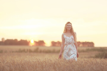 Fototapeta na wymiar romantic girl posing in a summer field dress