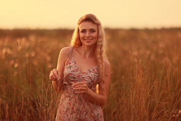 Obraz premium romantic girl posing in a summer field dress
