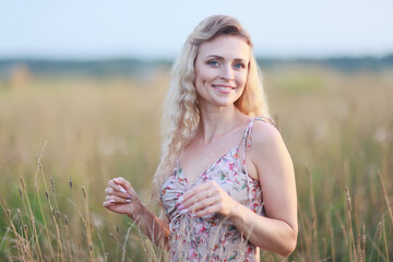 romantic girl posing in a summer field dress