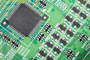 Close-up of a green computer printed circuit board with selective focus on a chip