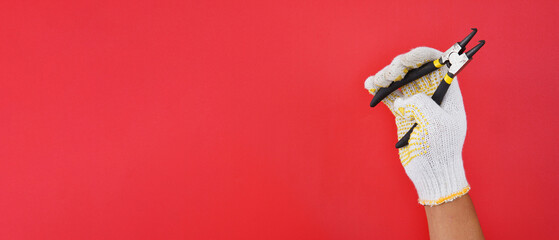 hand wearing white gloves holding snap ring, bent pliers isolated red background