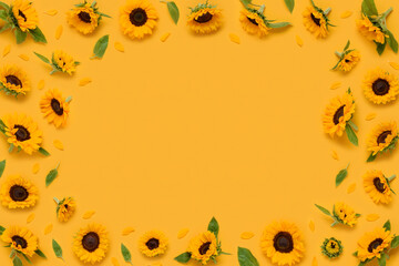 Ornamental sunflower flowers frame border with leaves buds and petals on yellow background top view...