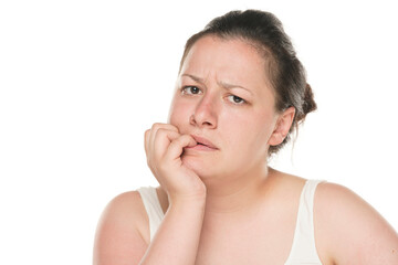 portrait of a nervous young chubby woman bite her fingernails