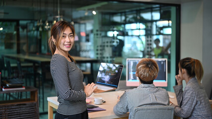 Software engineers team leader standing with laptop and smiling to camera. Developing programming and coding technologies concept