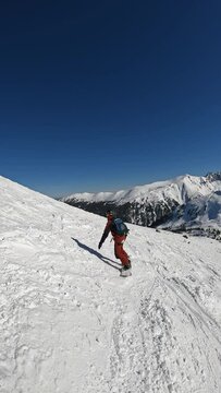 vertical video Young man snowboard shredding fresh powder snow
