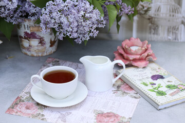 Fototapeta na wymiar still life with morning cup of tea and lilac flowers