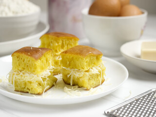 Martabak Keju, Indonesian Traditional Street Food Named Martabak Manis (Sweet Martabak) with Grated Cheese on WhiteTable. Selective focus