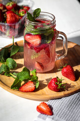 Photo of a strawberry cocktail with fresh green mint Cold summer lemonade with strawberries. 