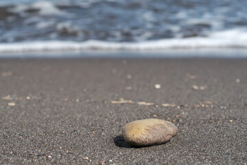 A stone at the famous beach of Perissa in Santorini Greece