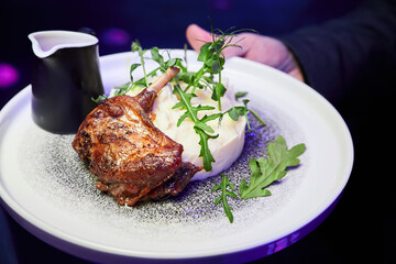 Roasted duck leg with mashed potatoes, arugula and sauce