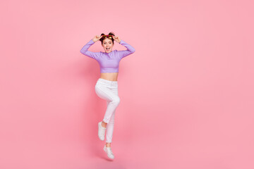 Full length body size view of attractive cheery thin girl jumping having fun isolated over pink pastel color background