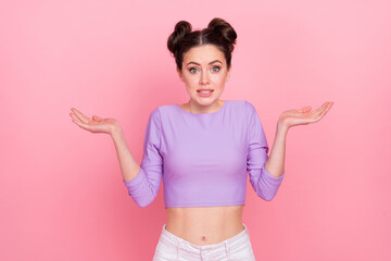 Fototapeta na wymiar Portrait of attractive confused girl shrugging shoulders dont know isolated over pink pastel color background