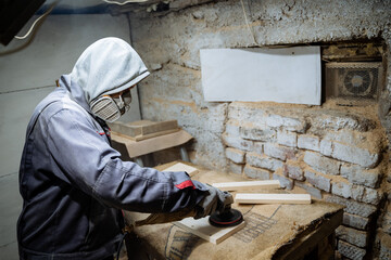 Naklejka na ściany i meble A joiner polishes the board. The process of processing boards in the carpentry workshop. Crafting.