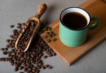 Green cup of coffee with coffee beans

