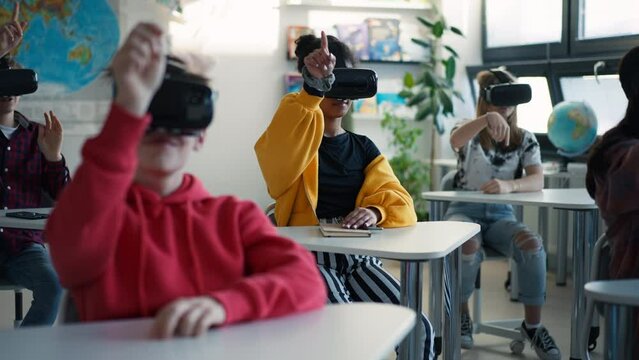 Teenage students wearing virtual reality goggles at school in computer science class