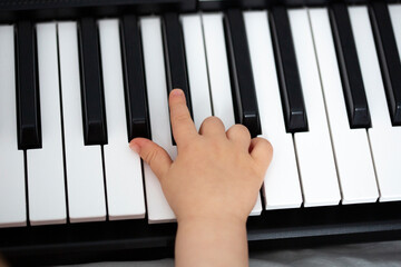 child's hands on piano keys