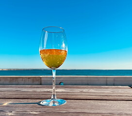  glass with limonade wooden table  on the beach in sea port blue sky  sun beam reflection and  scene