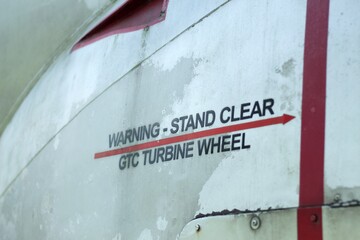 Warning stand clear turbine wheel decal on an old aircraft. - obrazy, fototapety, plakaty