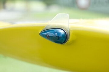 Blue aviation navigation lights on yellow wing of an old aircraft.