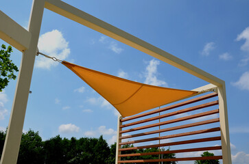 yellow canvas stretched, shading from the sun and rain over the terrace of the restaurant, on the...