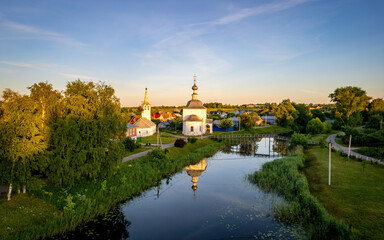 Fototapeta na wymiar Aerial views of Russian Golden Ring town Suzdal on a sunrise (aerial drone photo). Suzdal, Russia