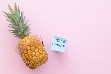 Hipster pineapple with trendy sunglasses against pink background. Minimal summer concept.