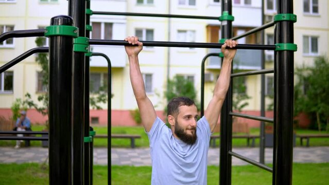 A man of Arab appearance on pull -up bars does exe