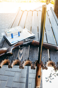 Shooting sports equipment for trap shooting on wooden table. Air-gun and bullets.