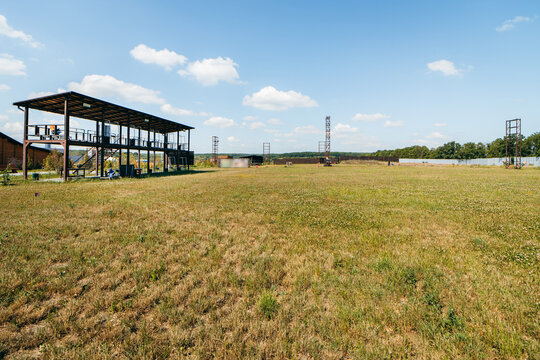 Empty shotgun training field with green grass and plat machines