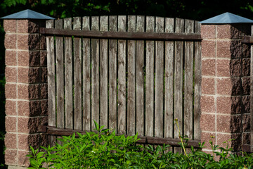 panels of a classic wooden featheredge garden fence with concrete support posts