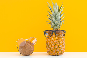 Pineapple and coconut with sunglasses resting and drink cocktail on the beach, Summer vacation concept
