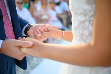 Anonymous newlyweds holding hands during wedding ceremony