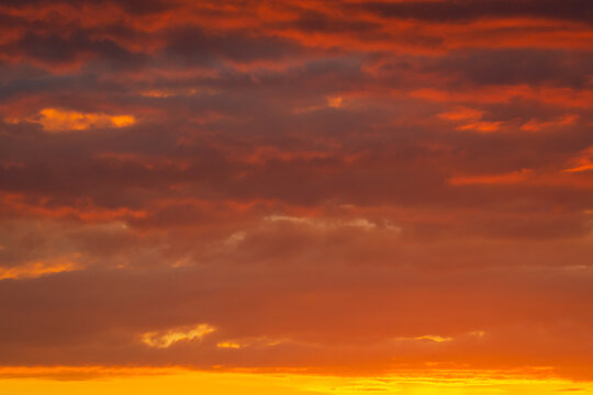 Colorful clouds of various shades on sunrise sky. Abstract and dramatic clouds background.