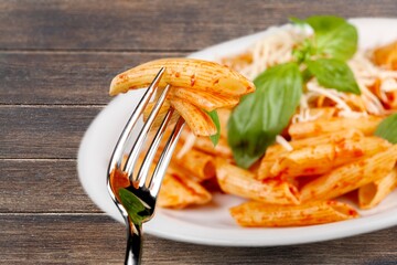 spaghetti pasta in a white plate with ketchup sauce