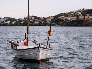 Naklejka na ściany i meble Typical Menorcan boat anchored in the small port of Cales Fonts, Menorca.