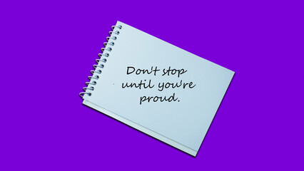 Hand writing note Don't stop until you're Proud notebook. lifestyle, advice, support motivational positive words are written on a wooden background. Business, signs, symbols, concepts. Copy space.
