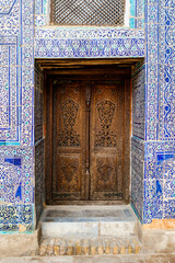 Mosaics and old wooden door inside of the Ark fortress in Khiva, Uzbekistan, Central Asia